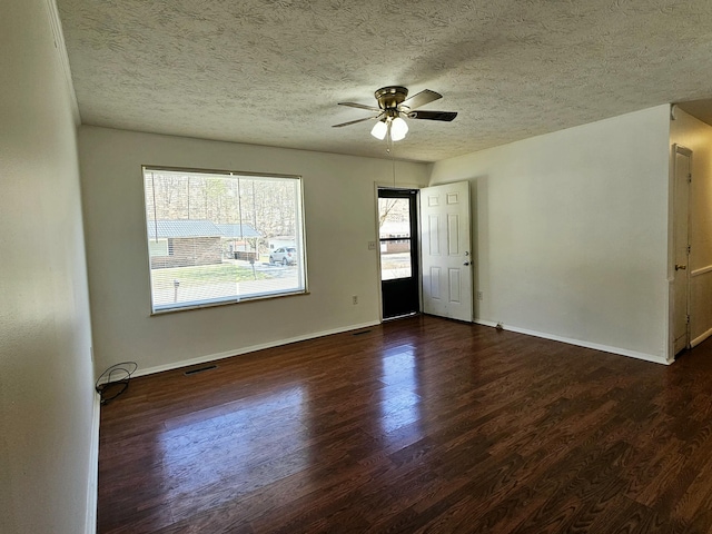 unfurnished room with ceiling fan, wood finished floors, visible vents, and baseboards