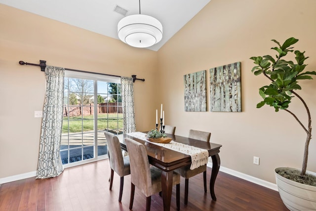 dining area with visible vents, vaulted ceiling, baseboards, and dark wood finished floors