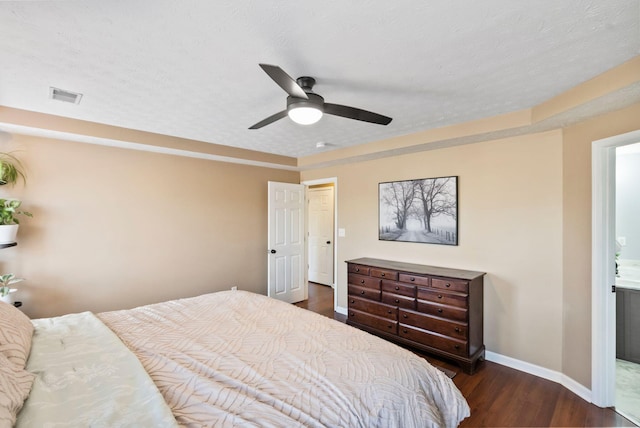 bedroom with baseboards, visible vents, ceiling fan, dark wood-type flooring, and ensuite bathroom