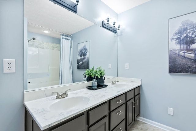 full bath featuring double vanity, a shower with curtain, baseboards, and a sink