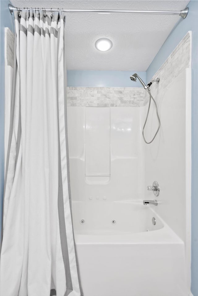 full bathroom with shower / tub combo and a textured ceiling