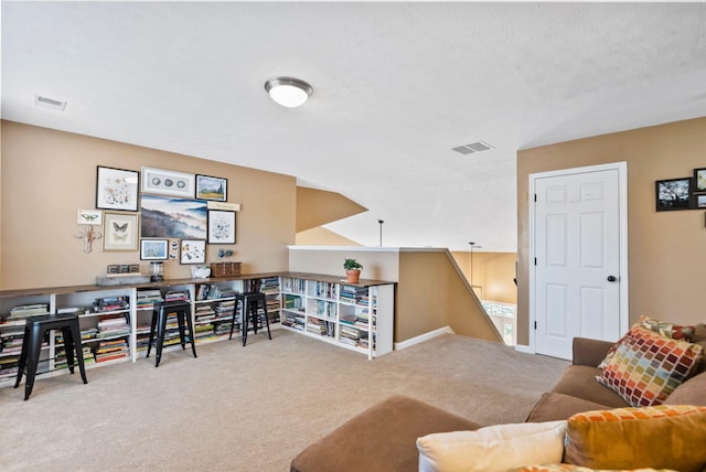 living area featuring a textured ceiling, visible vents, and carpet flooring