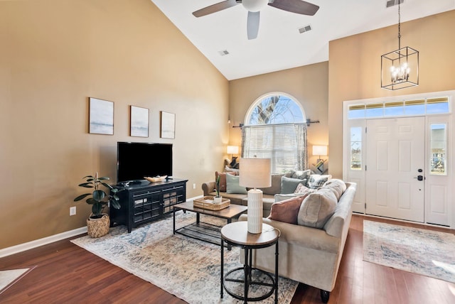 living area with high vaulted ceiling, baseboards, visible vents, and dark wood-type flooring