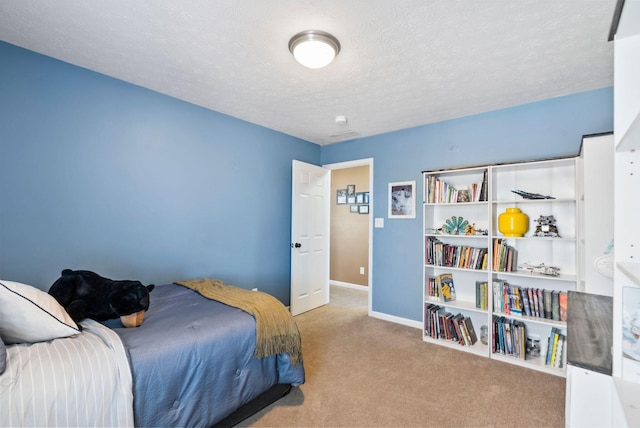 bedroom featuring light colored carpet, a textured ceiling, and baseboards