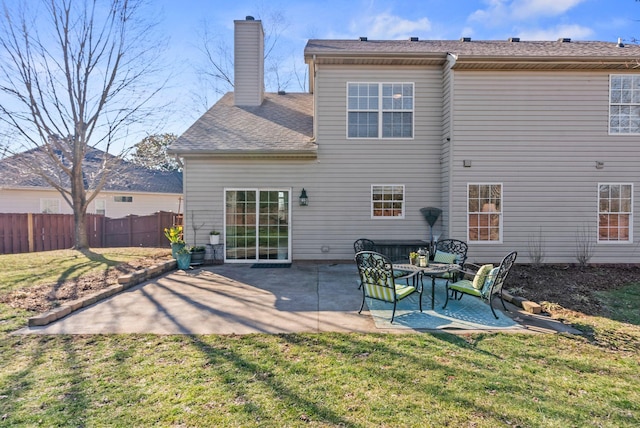 rear view of property featuring a patio area, a lawn, a chimney, and fence