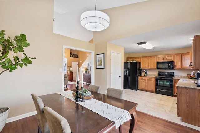 dining room with light wood-type flooring and baseboards