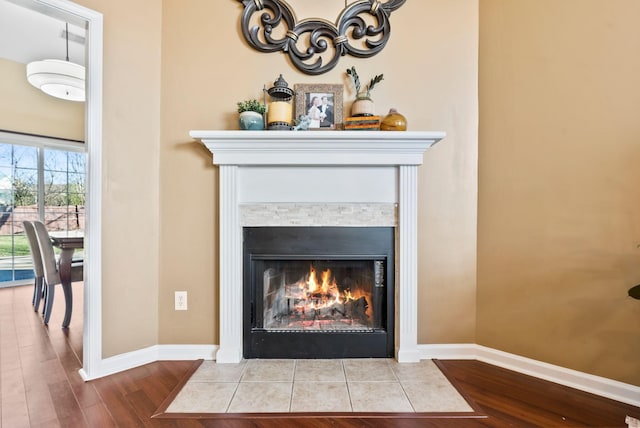 details with wood finished floors, a fireplace with flush hearth, and baseboards