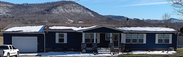 single story home with a mountain view and an attached garage