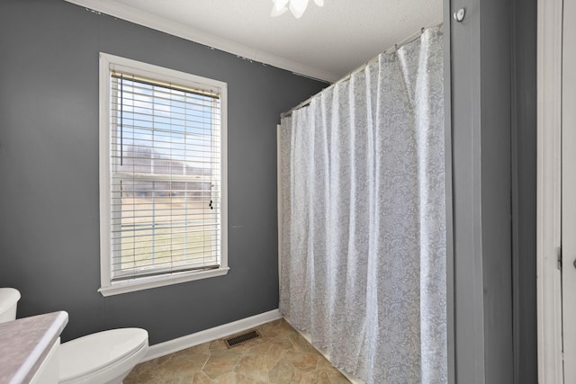 full bath with baseboards, a healthy amount of sunlight, visible vents, and toilet