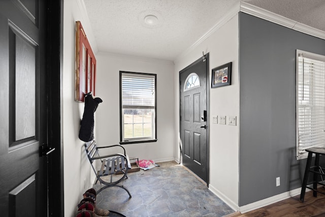 entrance foyer featuring ornamental molding, a textured ceiling, and baseboards