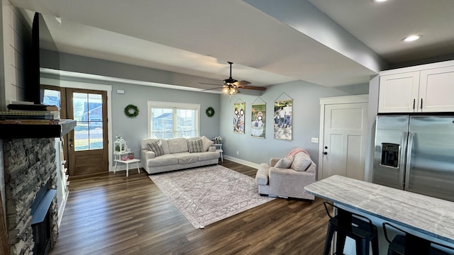 living area with baseboards, ceiling fan, dark wood-type flooring, a fireplace, and recessed lighting