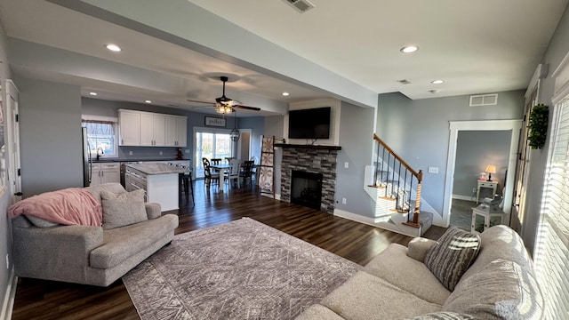 living room featuring baseboards, visible vents, dark wood-style flooring, stairs, and recessed lighting