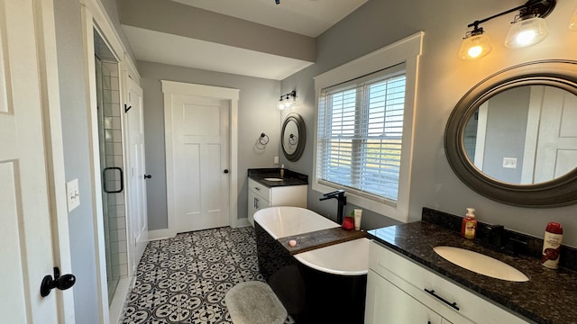 bathroom with two vanities, a sink, a shower stall, tile patterned flooring, and baseboards