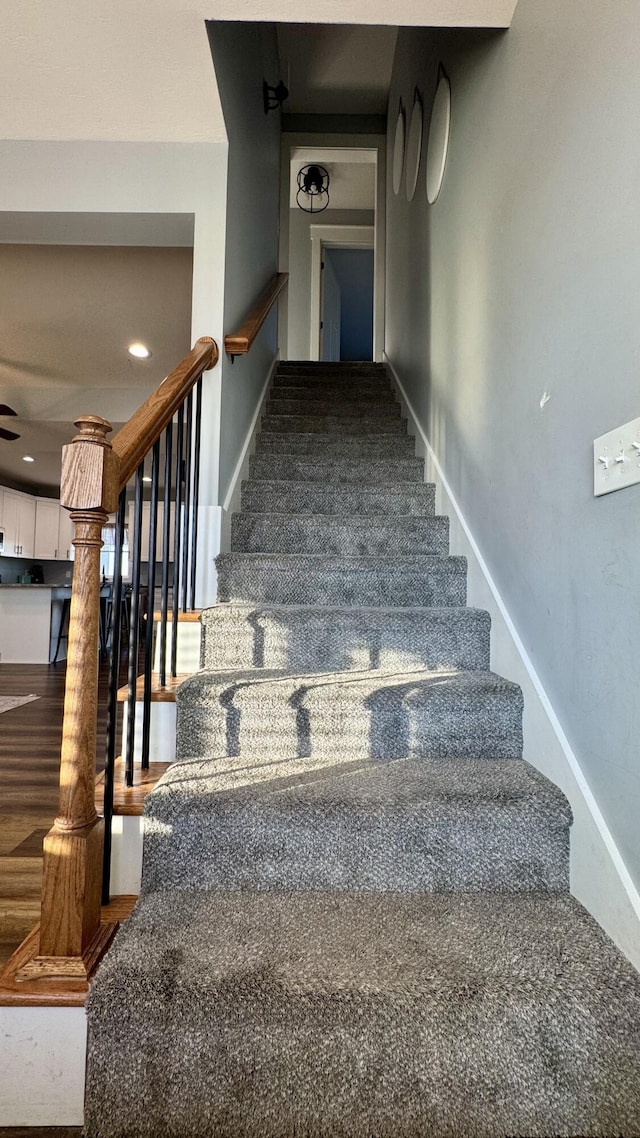 stairway with baseboards and wood finished floors