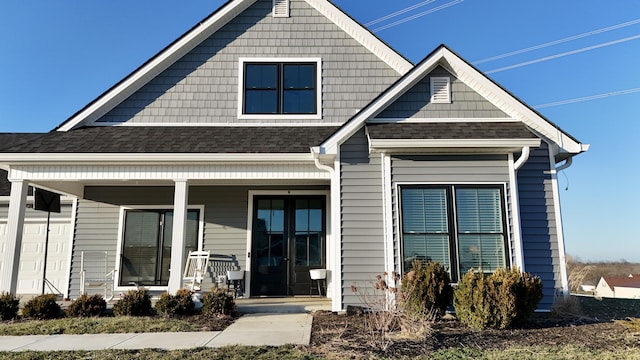 view of front of home with covered porch and a shingled roof