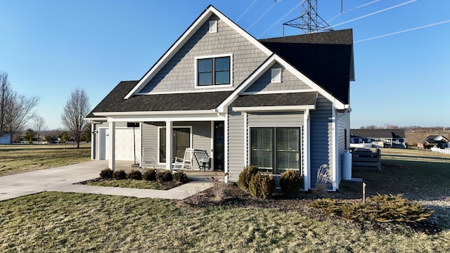 view of front of property with a porch, a front yard, concrete driveway, and roof with shingles