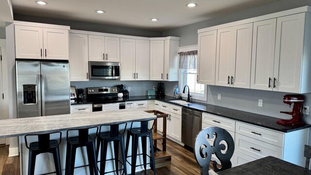 kitchen with appliances with stainless steel finishes, a sink, and white cabinets