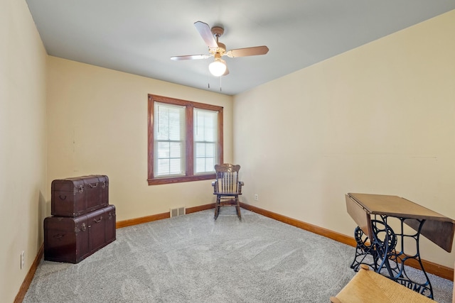 interior space featuring baseboards, visible vents, a ceiling fan, and light colored carpet