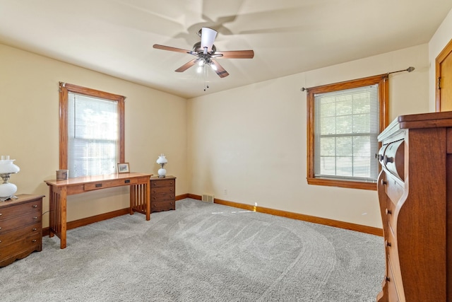 office space featuring light carpet, plenty of natural light, and baseboards