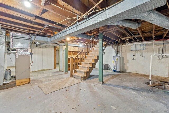 unfinished below grade area featuring heating unit, stairway, and gas water heater