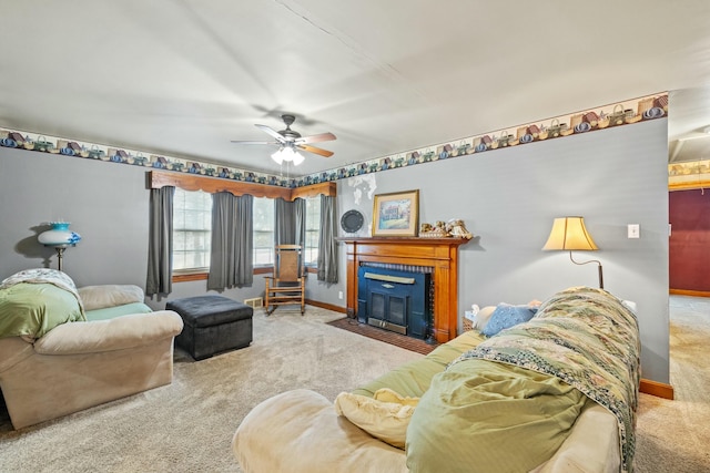 living room featuring carpet floors, a fireplace with flush hearth, a ceiling fan, and baseboards