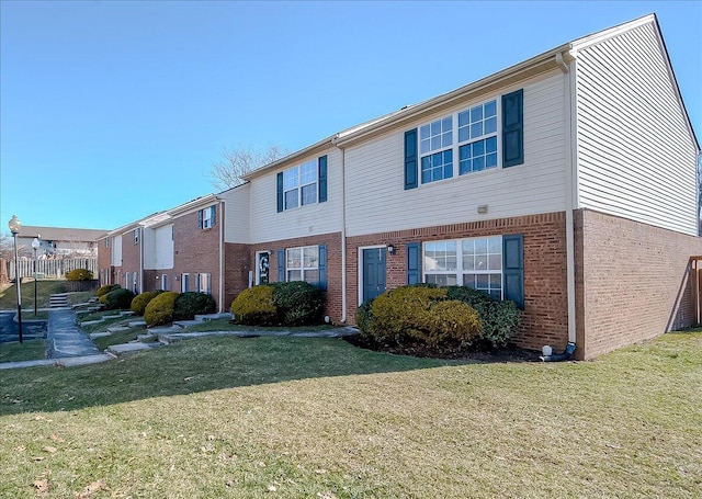 view of front of home featuring brick siding and a front lawn