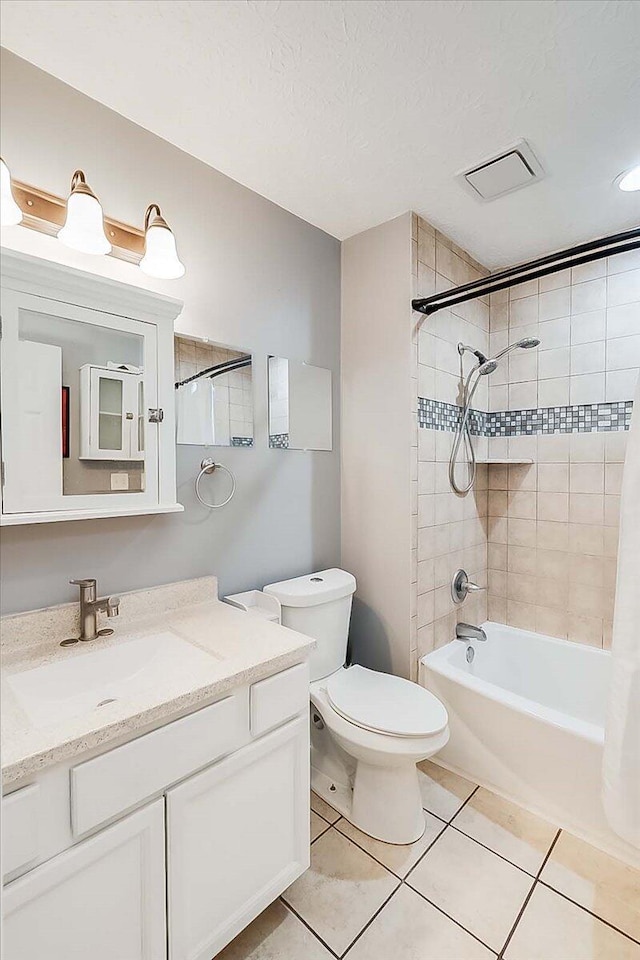 bathroom with a textured ceiling, toilet, vanity, shower / washtub combination, and tile patterned floors