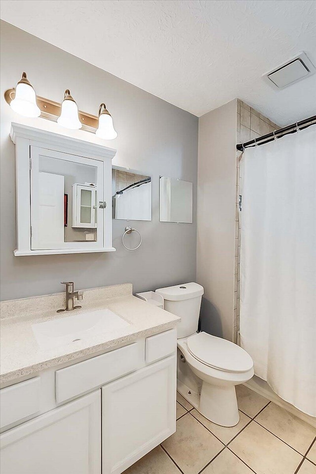 full bath featuring a textured ceiling, tile patterned flooring, toilet, vanity, and visible vents