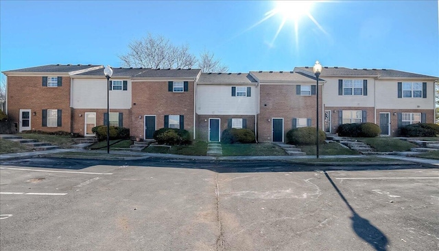 view of front of house featuring uncovered parking and brick siding