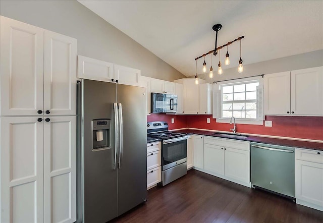 kitchen featuring dark countertops, white cabinetry, appliances with stainless steel finishes, and a sink