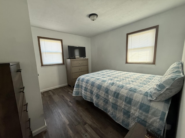 bedroom featuring dark wood-style floors and baseboards