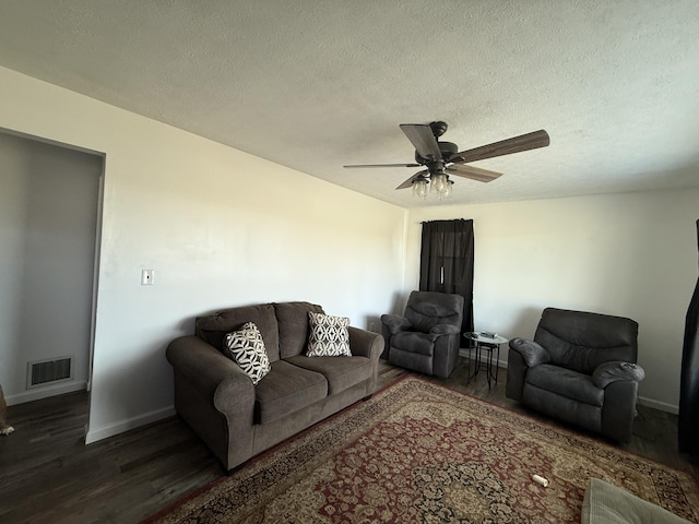 living area with baseboards, visible vents, dark wood finished floors, ceiling fan, and a textured ceiling