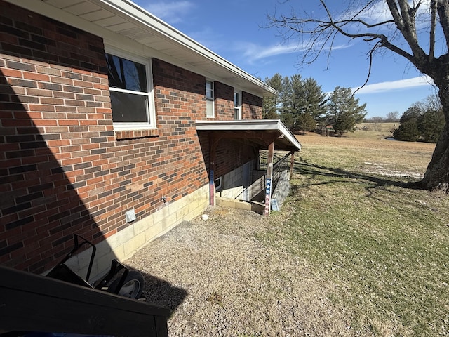 view of property exterior with brick siding and a lawn