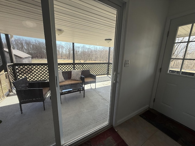 doorway featuring baseboards and tile patterned floors