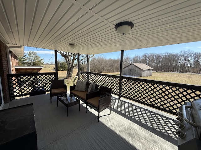 wooden terrace with a storage unit, an outdoor living space, and an outdoor structure