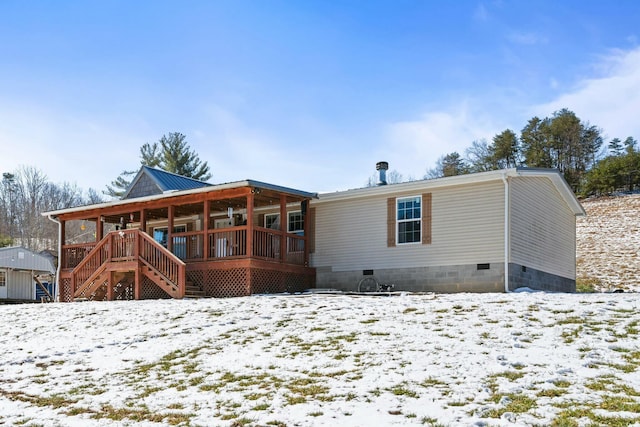 snow covered house with crawl space, stairs, and metal roof