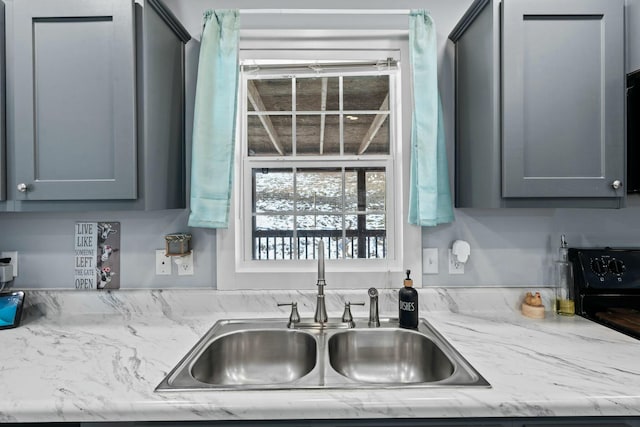 kitchen with a sink and gray cabinetry