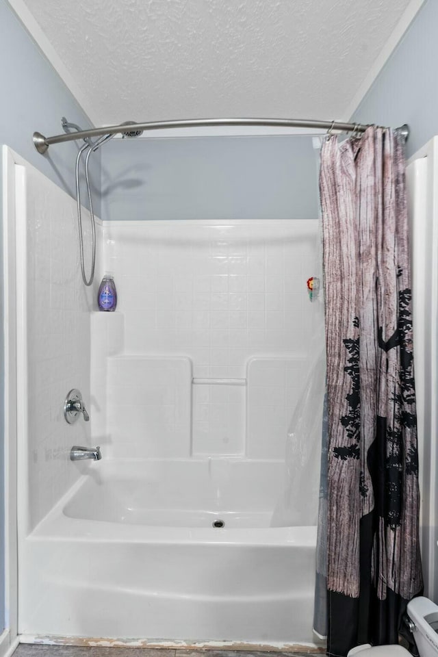 full bathroom featuring shower / tub combo with curtain, a textured ceiling, and toilet