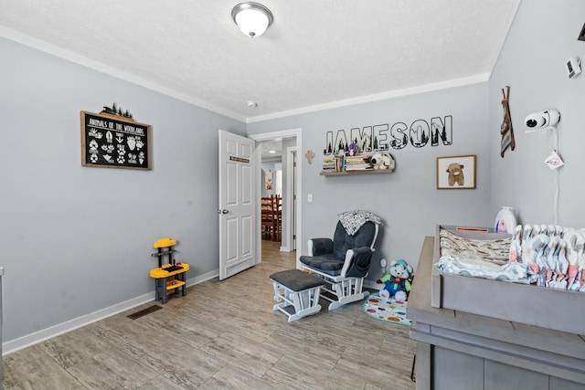 interior space featuring ornamental molding, visible vents, a textured ceiling, and baseboards