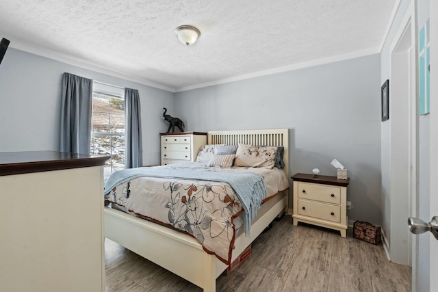 bedroom with a textured ceiling and wood finished floors