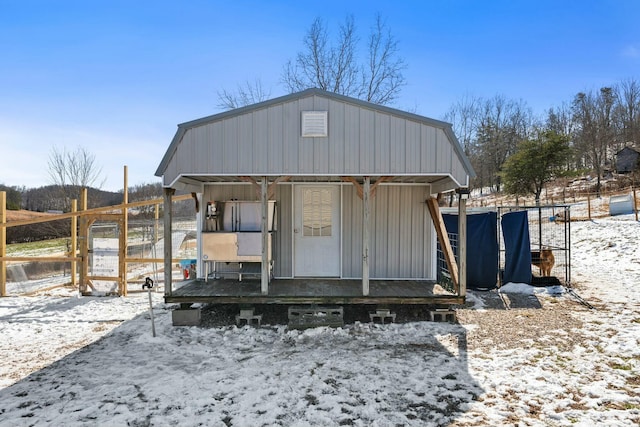 snow covered structure with an outbuilding