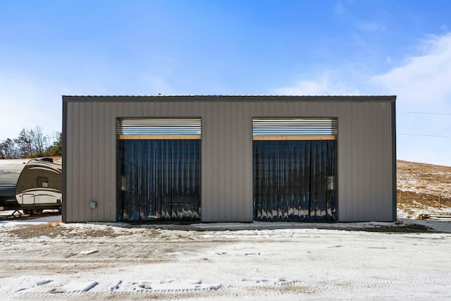 snow covered garage featuring a garage