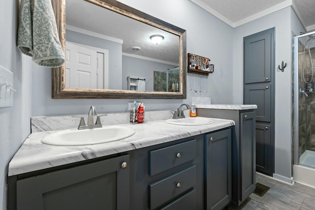 full bathroom featuring a shower with door, a sink, a textured ceiling, and double vanity