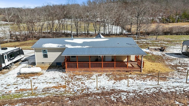 snow covered property featuring crawl space, covered porch, and metal roof