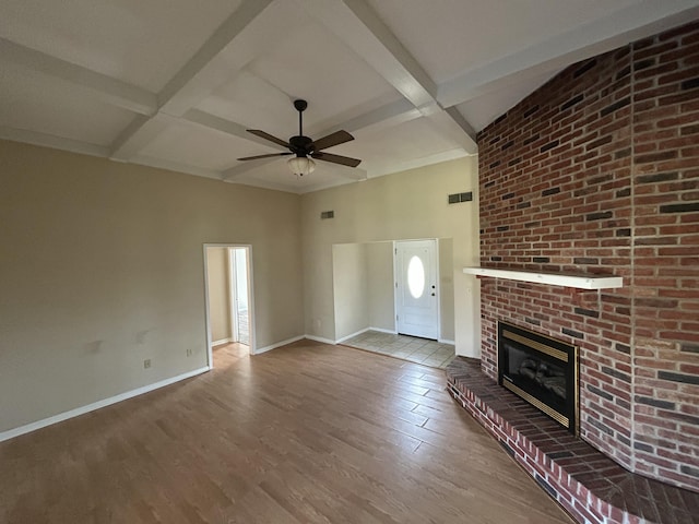 unfurnished living room with ceiling fan, coffered ceiling, a fireplace, wood finished floors, and baseboards