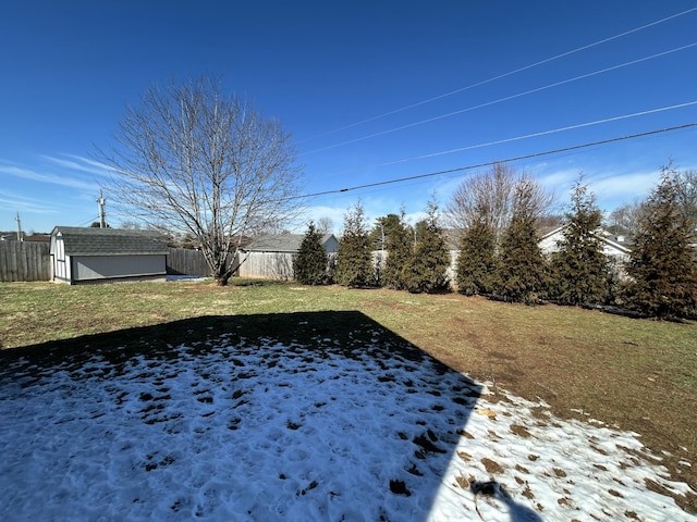 view of yard with fence, an outdoor structure, and a shed