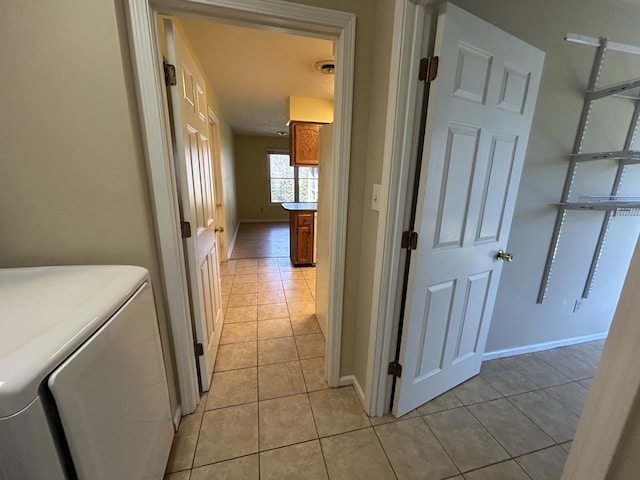 hallway featuring baseboards and light tile patterned floors