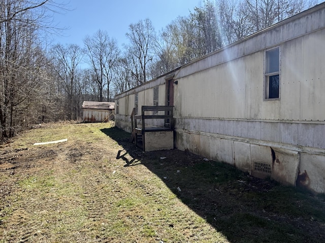 view of side of home with crawl space and an outdoor structure