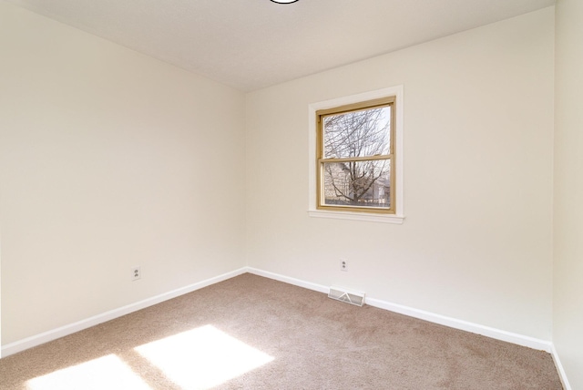 empty room featuring carpet floors, baseboards, and visible vents