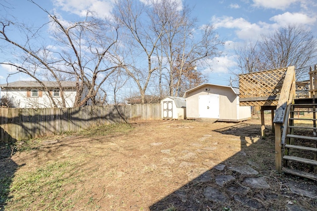 view of yard with stairs, a storage unit, an outdoor structure, and fence